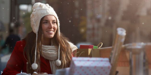 Christmas shopper with coffee and presents in snow