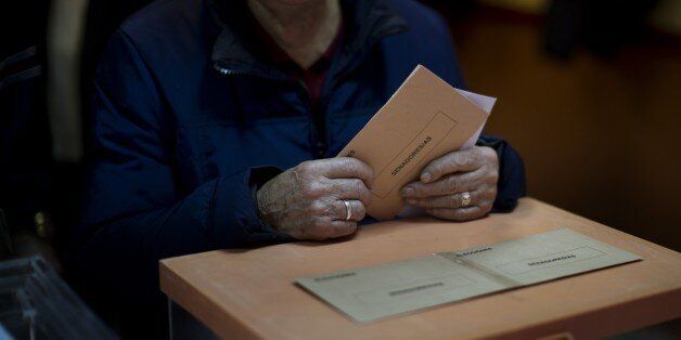 A woman holds her vote before casting it for the national elections in Madrid, Sunday, Dec. 20, 2015. Spaniards are voting in an historic national election Sunday with the countryâs traditional two-parties and widely anticipated strong showings for two new parties. (AP Photo/Emilio Morenatti)