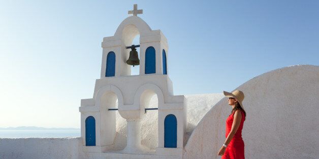 Woman in red walking in greek town, Santorini