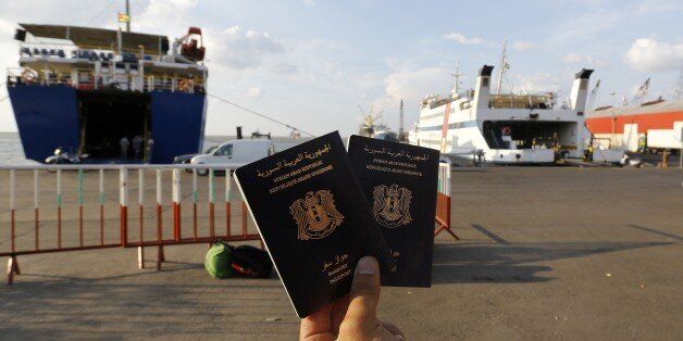 TO GO WITH AFP STORY A Syrian man holds Syrian passports as he waits to board a passenger ferry heading to Turkey at Lebanon's northern port city of Tripoli on October 6, 2015. Everyday, hundreds of Syrians escaping Syria's war board cruise ships in Tripoli bound for Turkey as they set out on the first stage of their journey to build a new life. AFP PHOTO / ANWAR AMRO (Photo credit should read ANWAR AMRO/AFP/Getty Images)