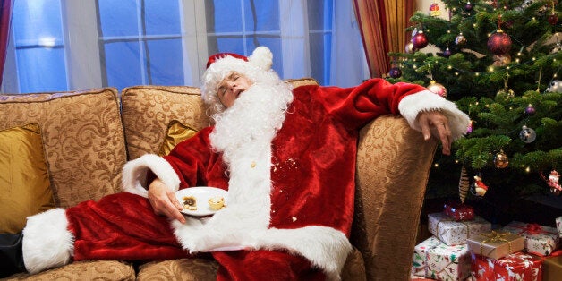 Father christmas is sleeping on sofa.