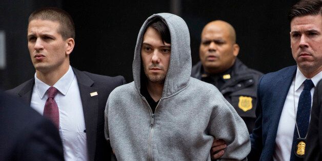 Martin Shkreli, the former hedge fund manager under fire for buying a pharmaceutical company and ratcheting up the price of a life-saving drug, is escorted by law enforcement agents in New York Thursday, Dec. 17, 2015, after being taken into custody following a securities probe. A seven-count indictment unsealed in Brooklyn federal court Thursday charged Shkreli with conspiracy to commit securities fraud, conspiracy to commit wire fraud and securities fraud. (AP Photo/Craig Ruttle)
