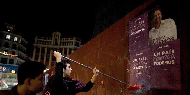 MADRID, SPAIN - DECEMBER 18: Podemos (We Can) party supporters put up electoral campaign posters along the street hours before the campaign ends at the Madrid Wax Museum on December 18, 2015 in Madrid, Spain. Over 36 million Spaniards will flock to the polls on Sunday December 20, 2015 to vote for 350 members of the parliament and 208 senators. For the first time since 1982, the two traditional Spanish political parties, right-wing Partido Popula (People's Party) and centre-left wing Partido Socialista Obrero Espanol PSOE (Spanish Socialist Workers' Party), are holding a tight election race with two new contenders, Ciudadanos (Citizens) and Podemos (We Can) attracting right-leaning and left-leaning voters respectively. (Photo by Pablo Blazquez Dominguez/Getty Images)