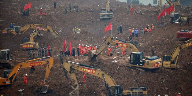 Rescuers use machinery to search for potential survivors following a landslide in Shenzhen, in south China's Guangdong province, Monday, Dec. 21, 2015. A mountain of excavated soil and construction waste buried dozens of buildings when it swept through an industrial park Sunday. (AP Photo/Andy Wong)
