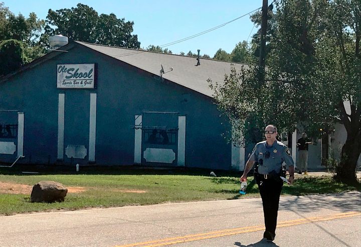 A Lancaster County Sheriff's deputy walks around the Old Skool Sports Bar and Grill, the scene of a shooting early in the morning, north of Lancaster, S.C. on Saturday, Sept. 21, 2019.