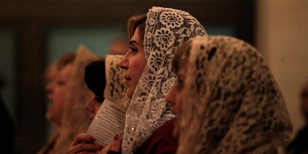 Syrian, Iraqi and Jordanian Orthodox Christians pray in front of the altar at the Saint Afram Syrian Orthodox Church during the midnight Christmas Mass in Amman, Jordan, Tuesday, Dec. 24, 2013. Hundreds of Syrian and Iraqi refugees along with Jordanian Christians attend the midnight Mass and pray for peace in their countries. (AP Photo/Mohammad Hannon)