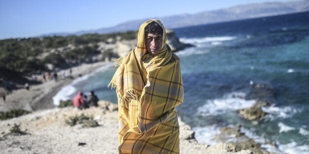 A youth wrapped in a blanket waits for the wind to calm down to travel on a dinghy with other migrants and refugees to the Greek island of Chios from Cesme in the Turkish province of Izmir on November 3, 2015. Amnesty International criticised Europe's failure to stop migrant deaths in the Aegean Sea as the death toll from ramshackle boats sinking off Greece rises daily. The group said over 450 refugees and migrants had died or gone missing in successive Aegean Sea sinkings in the first 10 months