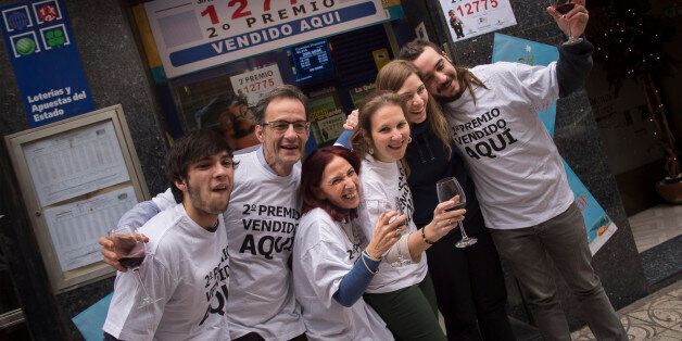 Cristina Ruiz, third left, 53, celebrates in front of a lottery office with red wine beside others owners after selling the second Christmas lottery prize ''El Gordo, in Logrono, northern Spain, Tuesday, Dec. 22, 2015. Celebrations were guaranteed Tuesday in the southern beach town of Roquetas de Mar where tickets bearing the top prize number of 79140 in Spain's Christmas lottery,
