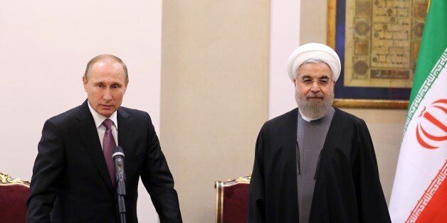 Iranian President Hassan Rouhani (R) and Russian counterpart Vladimir Putin hold a press conference following the Gas Exporting Countries Forum (GECF) summit in Tehran on November 23, 2015. Putin arrived in Tehran on his first trip to Iran in eight years, for talks on the devastating conflict in Syria where both countries support the Damascus regime. AFP PHOTO / ATTA KENARE / AFP / ATTA KENARE (Photo credit should read ATTA KENARE/AFP/Getty Images)