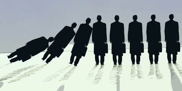 Row of businessmen falling in domino effect