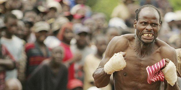VENDA, SOUTH AFRICA - DECEMBER 31: Khwthelani Ralukake celebrates while Mmbulawru Kota Mmbudzeni looks on during a traditional fist fighting match on December 29, 2006 in Tshaulu Village, Venda, South Africa. Venda's traditional fights or Musangwe, first started in the 1800s and only one man has died as a result, in 1939. Residents from different parts of the province gather for the annual Venda traditional fist fighting at the area called Gaba-Tshaulu. According to tradition no women are allowed to participate or even to watch.If their husbands are defeated by other men, women could lose their respect for their spouses.The venda fighting is called Musangwe. (Photo by Lefty Shivambu/Gallo Images/Getty Images)