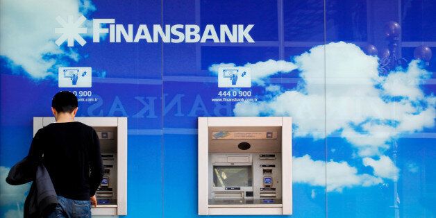 A customer uses a Finansbank automated teller machine (ATM) outside a branch in Istanbul, Turkey, on Tuesday, March 29, 2011. Finansbank AS, the Turkish bank owned by National Bank of Greece SA, said it will apply to banking and market regulators to offer as much as $750 million of bonds to investors outside Turkey. Photographer: Kerem Uzel/Bloomberg via Getty Images