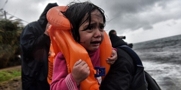 Refugees and migrants arrive at Lesbos island after crossing the Aegean sea from Turkey on October 23, 2015. Many Syrian families with small children are currently forced to walk a distance longer than the Athens Marathon from the beaches where they land to the points of registration near the port capital of Mytilene. Buses provided by local authorities and rides by volunteers do not suffice, especially as many refugees continue to land at night. Over 400,000 people have landed on Greek islands from neighbouring Turkey since the beginning of the year, most of them fleeing the civil war in Syria. AFP PHOTO / ARIS MESSINIS (Photo credit should read ARIS MESSINIS/AFP/Getty Images)