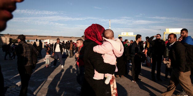 A woman carrying a baby disembarks from a ferry after their arrival from the Greek island of Lesbos at the Athens' port of Piraeus, Sunday, Oct. 4, 2015. The U.N. refugee agency is reporting a ânoticeable dropâ this week in arrivals of refugees by sea into Greece _ as the total figure for the year nears the 400,000 mark. Overall, the UNHCR estimates 396,500 people have entered Greece via the Mediterranean this year with seventy percent of them are from war-torn Syria. (AP Photo/Yorgos