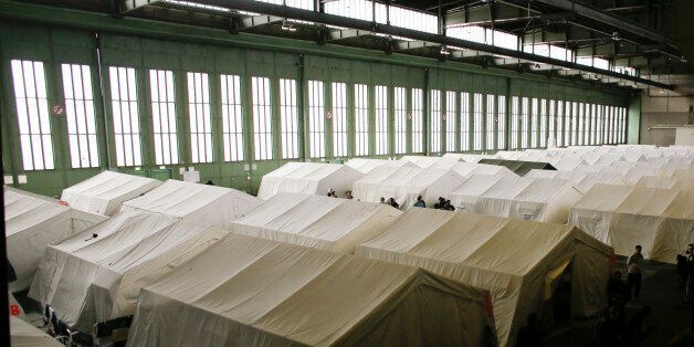 General view inside Hanger 1 of the former airport Tempelhof packed with tents as a temporary emergency shelter for over 2000 migrants, refugees and asylum seekers in Berlin, Wednesday, Dec. 9, 2015. German government says some 965,000 people were registered as asylum-seekers in Germany between January and the end of November, though the process has been chaotic at times. (AP Photo/Markus Schreiber)