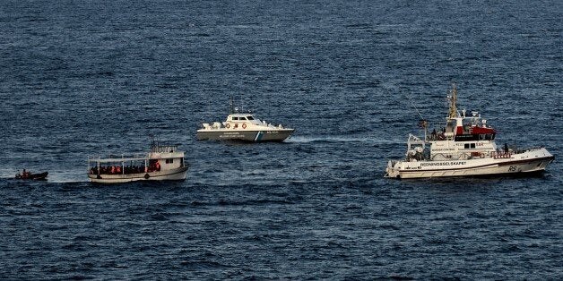 A boat carrying refugees and migrants is escorted by Greek coast guard and a Frontex boat off the coast of the Greek Lesbos island after crossing the Aegean Sea from Turkey on November 7, 2015. Nearly 500 people have died trying to cross the Aegean Sea from neighbouring Turkey this year, many of them in the narrow but treacherous stretch separating Lesbos from Turkey. AFP PHOTO / ARIS MESSINIS (Photo credit should read ARIS MESSINIS/AFP/Getty Images)