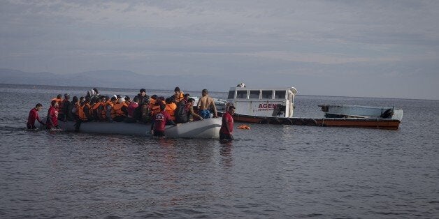 LESBOS ISLAND, GREECE - DECEMBER 02: Volunteers help refugees upon their arrival on the shore of Lesbos Island, Greece after crossing the Aegean sea from Turkey on December 02, 2015. (Photo by Ozge Elif Kizil/Anadolu Agency/Getty Images)