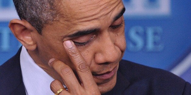 US President Barack Obama wipes his eye as he speaks during a previously unannounced appearance in the Brady Briefing Room of the White House on December 14, 2012 in Washington, DC. Obama spoke following the shooting in a Connecticut Elementary School which left at least 27 people dead. AFP PHOTO / Mandel NGAN (Photo credit should read MANDEL NGAN/AFP/Getty Images)