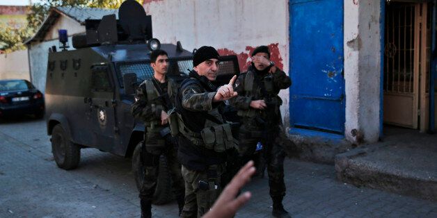 Turkish police officers prevent members of the media from taking pictures of them outside a polling station at the old city in Diyarbakir, in Turkey's predominantly Kurdish southeast, Sunday, Nov. 1, 2015. Turks headed to the polls Sunday for the second time in five months in what is being seen as a crucial general election that will determine whether the ruling party can restore the parliamentary majority it enjoyed for the past 13-years. (AP Photo/Lefteris Pitarakis)