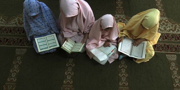 Palestinian girls attend a class on how to read the Koran, Islam's holy book, at a camp in a local mosque in Gaza City on June 11, 2012. AFP PHOTO/MAHMUD HAMS (Photo credit should read MAHMUD HAMS/AFP/GettyImages)