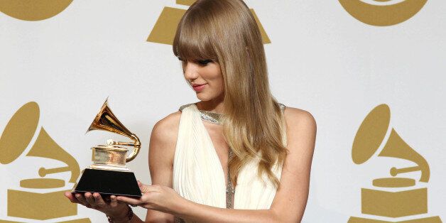 Taylor Swift poses backstage with the award for best song written for visual media for