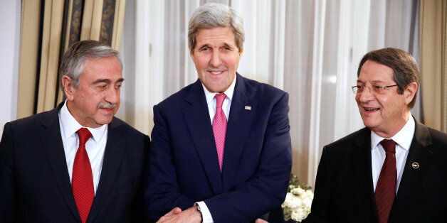 US Secretary of State John Kerry (C) shakes the hands of Cypriot President Nicos Anastasiades (R) and Turkish Cypriot leader Mustafa Akinci (L) ahead of a a dinner at the UNFICYP Residence in Nicosia on December 3, 2015. Kerry's visit to Cyprus comes in a bid to boost intensified peace talks to reunify the long-divided Mediterranean island. AFP PHOTO / POOL / JONAHTAN ERNST / AFP / POOL / JONATHAN ERNST (Photo credit should read JONATHAN ERNST/AFP/Getty Images)