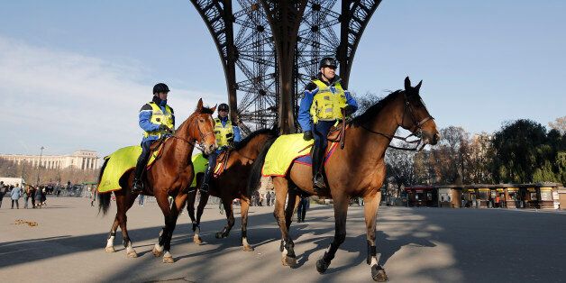 Mounted police officers patrol under the Eiffel Tower in Paris, Monday Nov. 23, 2015. French President Francois Hollande will preside over a national ceremony on Nov. 27 honoring the at least 130 victims of the deadliest attacks on France in decades. (AP Photo/Laurent Cipriani)