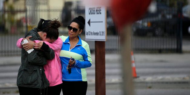 Kayla Gaskill, left, Gaskill's mother and Connie Pegler, right, pay respect at a makeshift memorial site honoring the victims of Wednesday's shooting rampage, Friday, Dec. 4, 2015, in San Bernardino, Calif. Gaskill said her friend Daniel Kaufman was killed in the shooting. (AP Photo/Jae C. Hong)