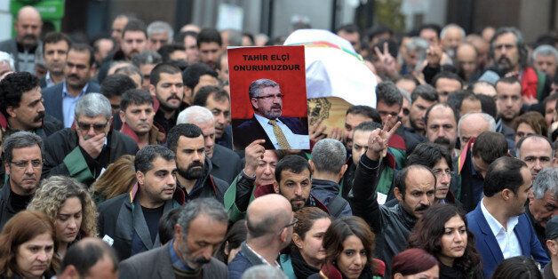 Thousands of people attend the funeral of Tahir Elci, president of the Diyarbakir Bar Association and a leading human rights defender, in Diyarbakir, Turkey, Sunday, Nov. 29, 2015. Elci was killed Saturday while making a press statement intended to call attention to damage done to the 1,500-year-old Four-Legged Minaret Mosque by recent clashes between Turkish security forces and Kurdistan Workers' Party militants.(AP Photo/Mahmut Bozarslan)