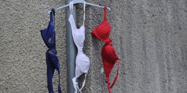 Bras in the colors of the French national flag hang from a house's gutter in La Rochelle, southwestern France, on NOvember 27, 2015 during a day of national tribute to the 130 people killed in the November 13 Paris attacks. AFP PHOTO / XAVIER LEOTY / AFP / XAVIER LEOTY (Photo credit should read XAVIER LEOTY/AFP/Getty Images)