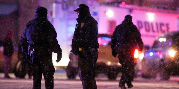 Police confer at an intersection near the scene of a shooting at a Planned Parenthood clinic Friday, Nov. 27, 2015, in Colorado Springs, Colo. A gunman opened fire at the clinic on Friday, authorities said, wounding multiple people. (AP Photo/David Zalubowski)