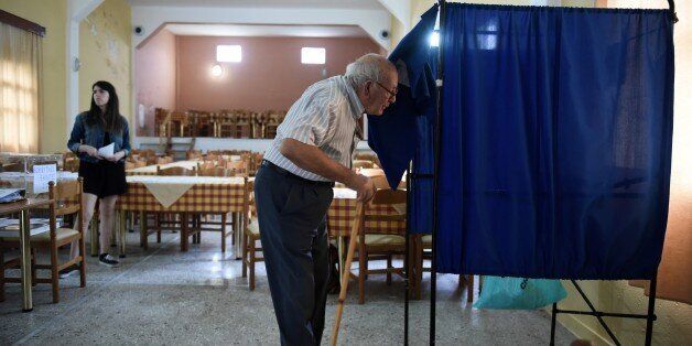 An elderly man enters an election booth to cast his vote at a polling station in Idomeni village, northern Greece, Sunday, Sept. 20, 2015. The small village of 100 registered voters is the last stop in Greece for thousands migrants and refugees arriving from Turkey who attempt to cross and head north toward more prosperous parts of the European Union. Greeks were voting Sunday in their third national poll this year, called on to choose who they trust to steer the country into its new international bailout. (AP Photo/Giannis Papanikos)