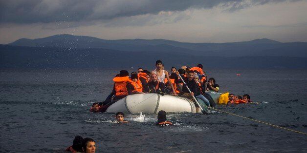 Volunteers help refugees to approach the coast after engine problems on their dinghy in the northeastern Greek island of Lesbos Wednesday, Nov. 25, 2015. About 5,000 migrants reaching Europe each day over the so-called Balkan migrant route. The refugee crisis is stoking tensions among the countries on the so-called Balkan migrant corridor â Greece, Macedonia, Serbia, Croatia and Slovenia. (AP Photo/Santi Palacios)