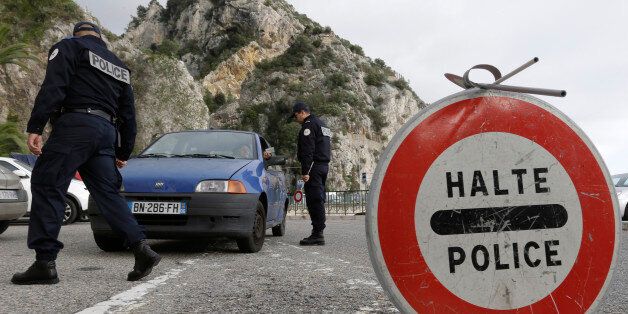 French customs control and check a car coming from Italy at the Franco-Italian border in Menton, southeastern France, Friday, Nov. 13, 2015. France reintroduces temporary controls at borders in preparation for the 2015 United Nations Climate Change Conference to be held in Paris from November 30 to December 11. (AP Photo/Lionel Cironneau)