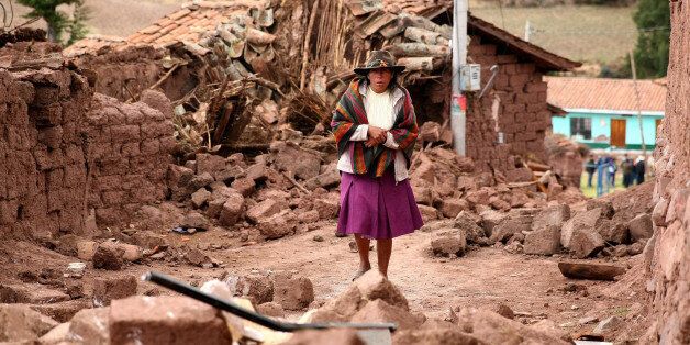 PARURO, PERU - SEPTEMBER 28: A Peruvian woman walks among the rubble of the houses affected by an 4.9 magnitude earthquake leaving at least eitgt death and five wounded in Paruro, Peru, on 28 September 2014. (Photo by Peru Presidency Handout Editorial Use Only/Anadolu Agency/Getty Images)