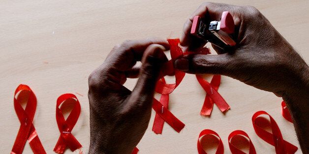 A HIV-positive person from the Support and Care Centre of the Sumanahalli Society prepares 'red ribbons' on the eve of World Aids Day in Bangalore on November 30, 2015. Globally about 36.9 million people are living with HIV including 2.6 million children, while the global response to HIV has averted 30 million new HIV infections and nearly 8 million deaths since 2000. AFP PHOTO/ Manjunath KIRAN / AFP / Manjunath Kiran (Photo credit should read MANJUNATH KIRAN/AFP/Getty Images)