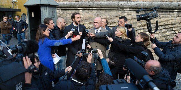 Journalists Gianluigi Nuzzi (R) and Emiliano Fittipaldi speak to reporters outside the Vatican on November 24, 2015 after the opening of the trial for the publication of classified documents. Two journalists and three Vatican officials face potential jail time of up to eight years for obtaining and disclosing confidential papers 'concerning the fundamental interests of the Vatican State'. AFP PHOTO / ANDREAS SOLARO / AFP / ANDREAS SOLARO (Photo credit should read ANDREAS SOLARO/AFP/Getty Images)