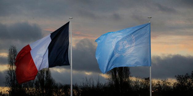 The flags of the U.N. and France fly as world leaders arrive for the COP21, United Nations Climate Change Conference, in Le Bourget, outside Paris, Monday, Nov. 30, 2015. (AP Photo/Christophe Ena, Pool)