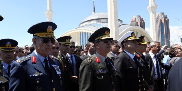 Turkish army's top commanders, Land Forces Commander Gen. Hulusi Akar, centre, Navy Commander Adm. Bulent Bostanoglu, third left, and Air Forces Commander Akin Ozturk, left, walk during a state funeral for Kenan Evren, the leader of Turkey's 1980 military coup and former president who died aged 97, at Akseki Mosque in Ankara, Turkey, Tuesday May 12, 2015. No government official attended the burial of the man remembered mostly for widespread arrests, torture and deaths during his rule. Evren died in a military hospital in Ankara on May 9 _ almost a year after he was sentenced to life imprisonment for leading the coup.(AP Photo/Burhan Ozbilici)