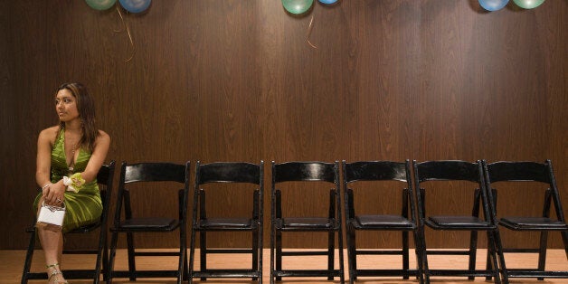 Hispanic teenaged girl sitting alone at prom