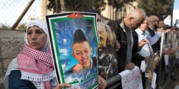Protesters hold posters of Palestinian teenager Mohammed Abu Khdeir, who was killed last year, outside the district court in Jerusalem on November 30, 2015. The Jerusalem court convicted two Israeli minors of the kidnapping and burning alive of a Palestinian teenager in the run-up to the 2014 Gaza war, while the third defendant Yosef Haim Ben-David's mental state will be evaluated. Mohammed Abu Khdeir, 16, was abducted and killed on July 2, 2014, weeks after the kidnapping and murder of three Is