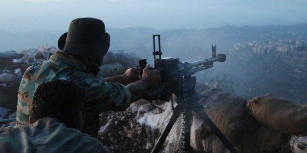 In this photo taken on Saturday, Oct. 10, 2015, Syrian army personnel fire a machine gun in Latakia province, about 12 miles from the border with Turkey, Syria. Backed by Russian airstrikes, the Syrian army has launched an offensive in central and northwestern regions. (Alexander Kots/Komsomolskaya Pravda via AP)