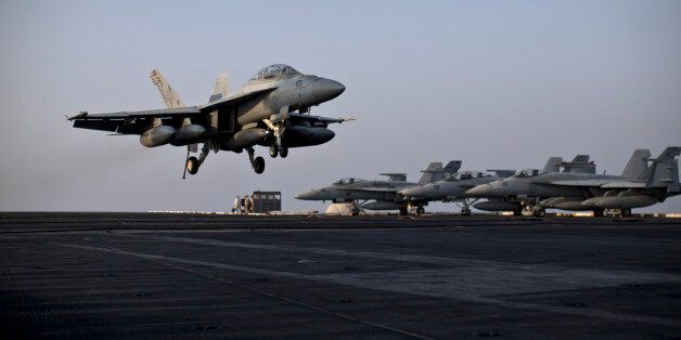 A U.S. Navy fighter jet is about to land on the flight deck of USS Theodore Roosevelt aircraft carrier, Thursday, Sept. 10, 2015. The carrier is currently deployed in the Persian Gulf, supporting Operation Inherent Resolve, the military operation against Islamic State extremists in Syria and Iraq. (AP Photo/Marko Drobnjakovic)