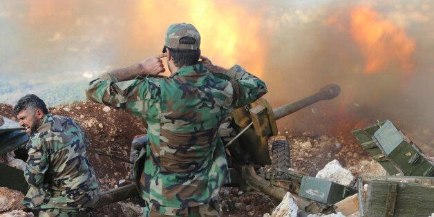 In this photo taken on Saturday, Oct. 10, 2015, Syrian army personnel fire a cannon in Latakia province, about 12 from the border with Turkey in Syria. Backed by Russian airstrikes, the Syrian army has launched an offensive in central and northwestern regions. (Alexander Kots/Komsomolskaya Pravda via AP)