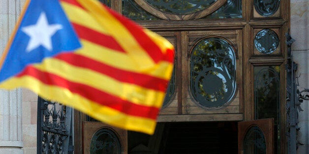 Regional acting President Artur Mas, center, waves to the crowd as he leaves Catalonia's high court after being questioned over their suspected roll in holding a poll in Barcelona, Spain, Thursday, Oct. 15, 2015. Thousands of people are rallying outside a Barcelona court in support of Catalan regional acting President Artur Mas who has arrived for questioning over the staging of a symbolic referendum on secession from Spain last year. (AP Photo/Manu Fernandez)