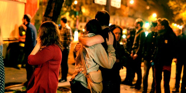 PARIS, FRANCE - NOVEMBER 13: Parisians look at the scene outside the Bataclan concert hall after an attack on November 13, 2015 in Paris, France. According to reports, over 120 people were killed in a series of bombings and shootings across Paris, including at a soccer game at the Stade de France and a concert at the Bataclan theater. (Photo by Pascal Le Segretain/Getty Images)