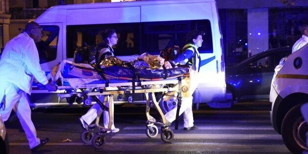 Rescuers evacuate an injured person on Boulevard des Filles du Calvaire, close to the Bataclan concert hall in central Paris, early on November 14, 2015. A number of people were killed in an 'unprecedented' series of bombings and shootings across Paris and at the Stade de France stadium on November 13, and the death toll looked likely to rise as sources said dozens had been killed at the Bataclan popular music venue. AFP PHOTO / MIGUEL MEDINA (Photo credit should read MIGUEL MEDINA/AFP/Ge