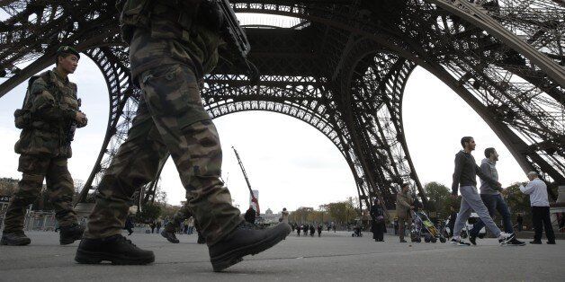 Soldiers patrol at the foot of the Eiffel Tower in Paris on November 16, 2015 three days after the terrorist attacks that left at least 129 dead and more than 350 injured. France prepared to fall silent at noon on November 16 to mourn victims of the Paris attacks after its warplanes pounded the Syrian stronghold of Islamic State, the jihadist group that has claimed responsibility for the slaughter. AFP PHOTO / KENZO TRIBOUILLARD (Photo credit should read KENZO TRIBOUILLARD/AFP/Getty Images)