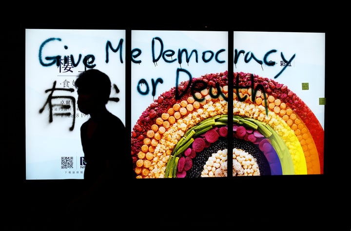 A person walks in front of graffiti in Tuen Mun, Hong Kong, on Sept. 21, 2019.