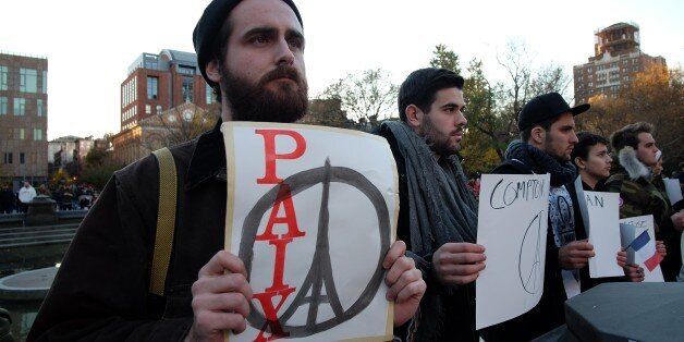 People display placards during a vigil to show solidarity with the citizens of France on November 14, 2015 in New York, a day after the Paris terrorist attacks. Islamic State jihadists claimed a series of coordinated attacks by gunmen and suicide bombers in Paris on November 13 that killed at least 129 people in scenes of carnage at a concert hall, restaurants and the national stadium. AFP PHOTO/JEWEL SAMAD (Photo credit should read JEWEL SAMAD/AFP/Getty Images)